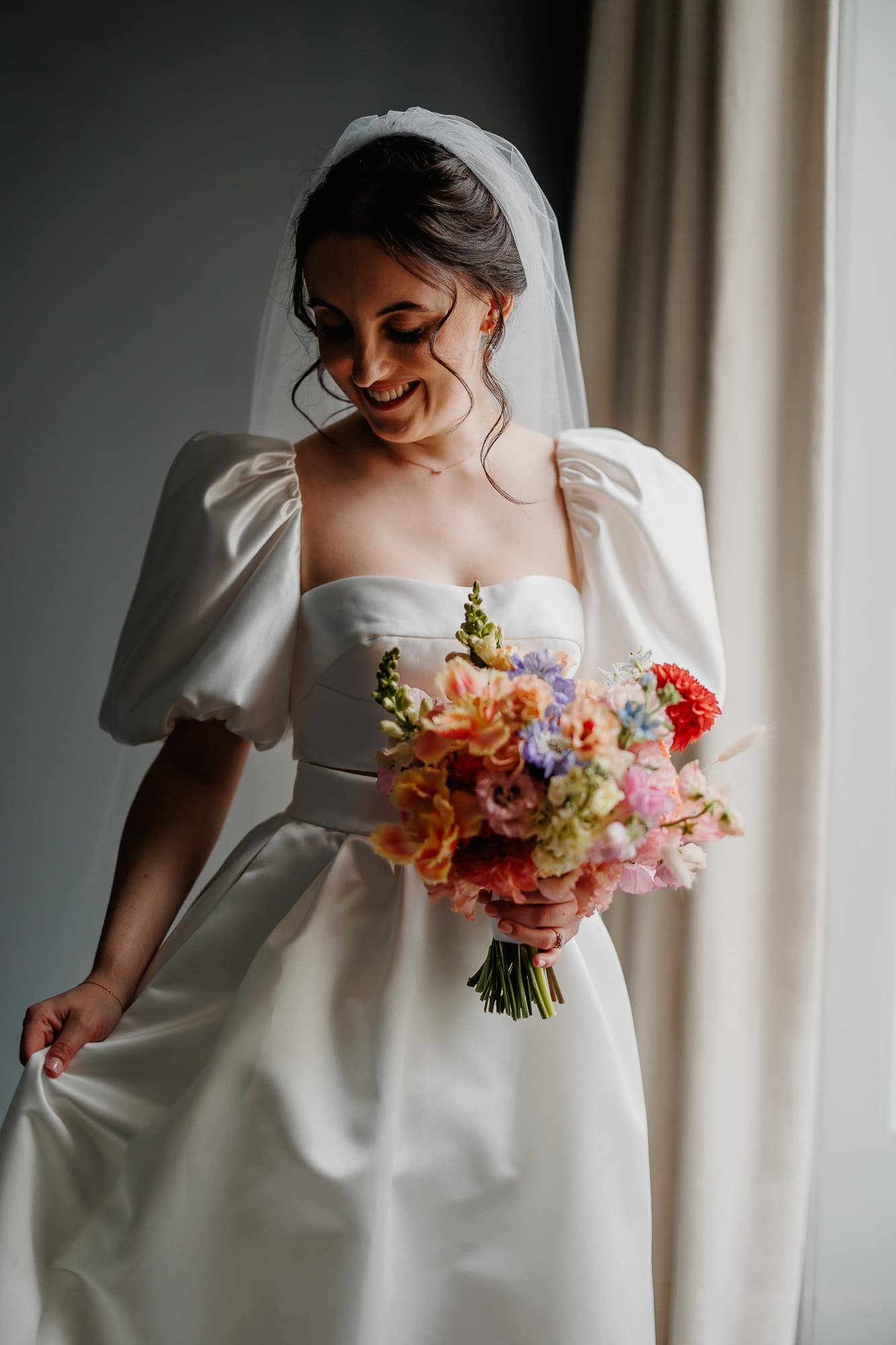 Bride in her Jesus Peiro wedding dress, beautifully illuminated by natural light from a window.