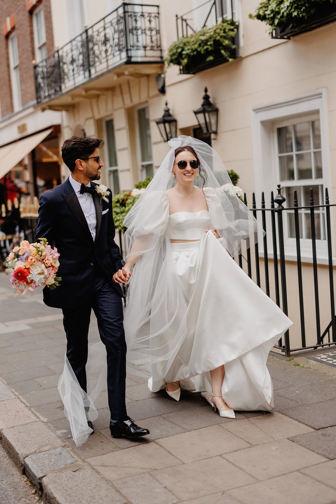 Bride and groom exude excitement, walking with fashionable flair and effortless style.