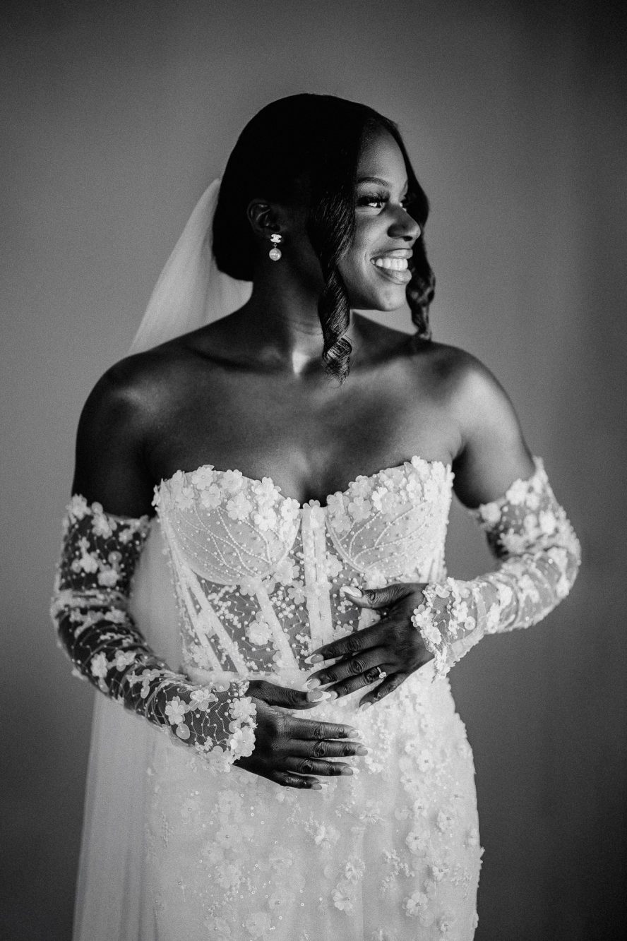 Black and white window-lit portrait of the bride in a stunning Blinova Bridal Couture wedding dress.