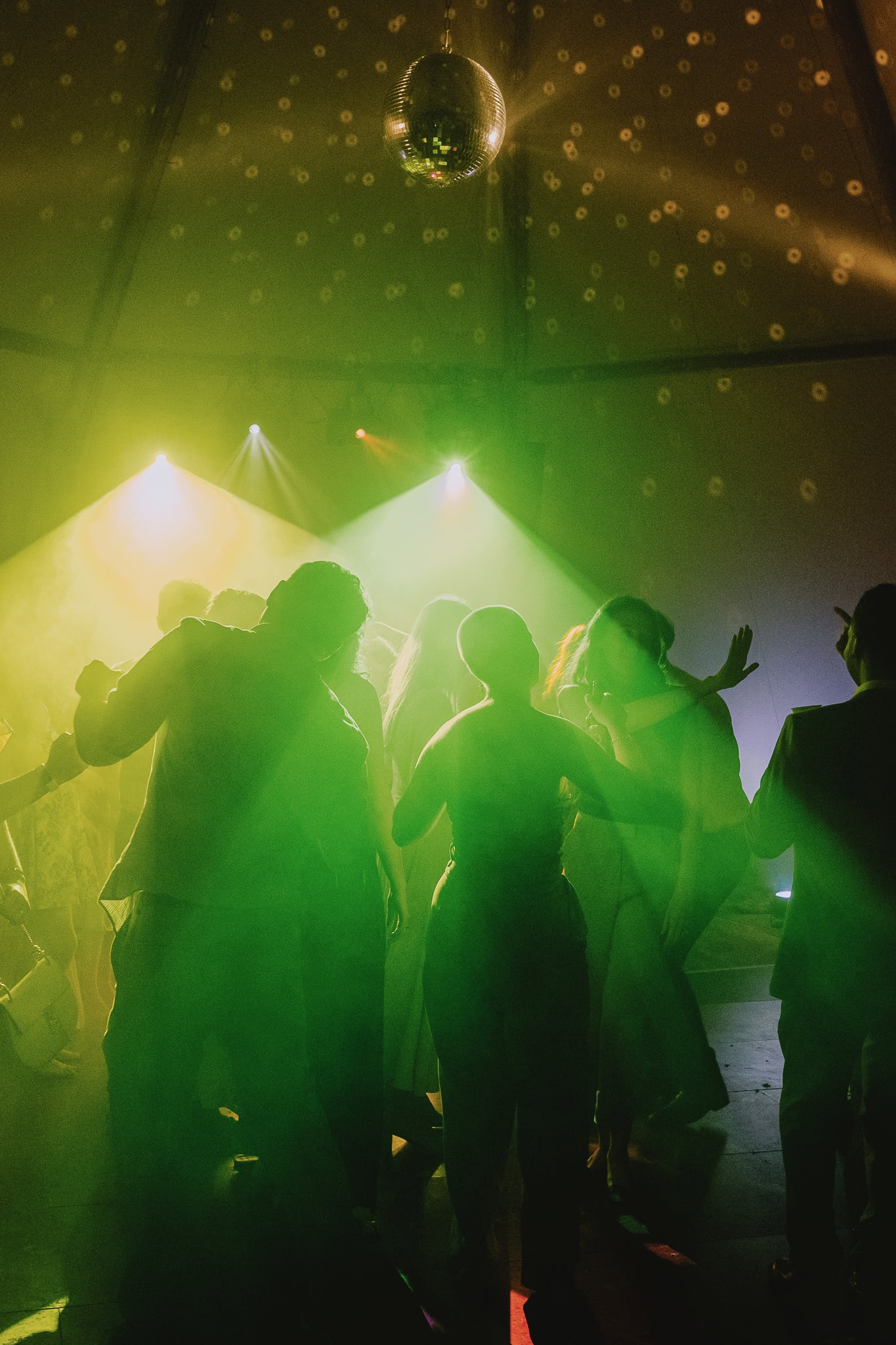 Wedding party dancing under a disco ball, wedding photography portfolio.