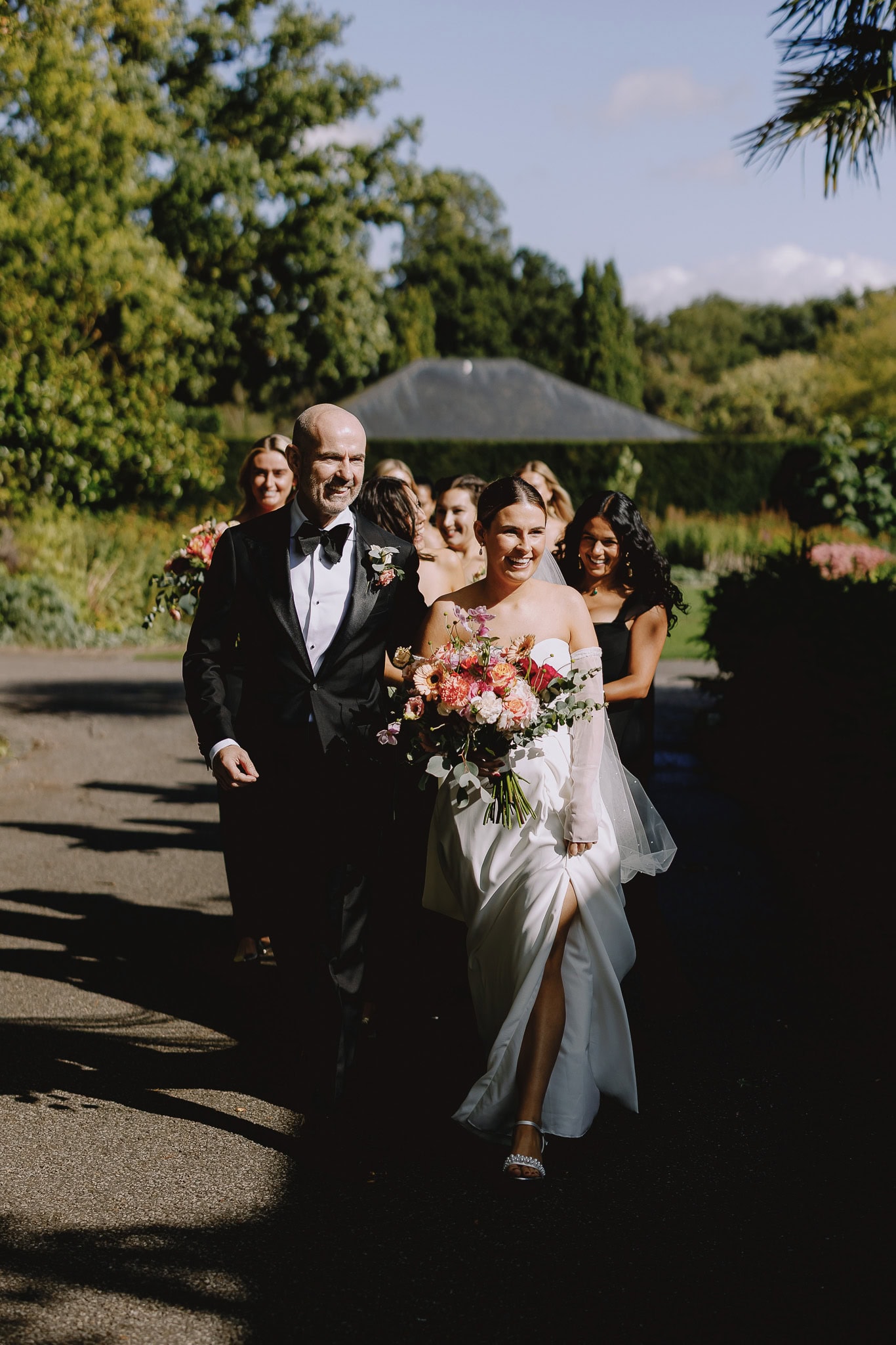Wedding photography portfolio: Bride and groom walking with bridesmaids.