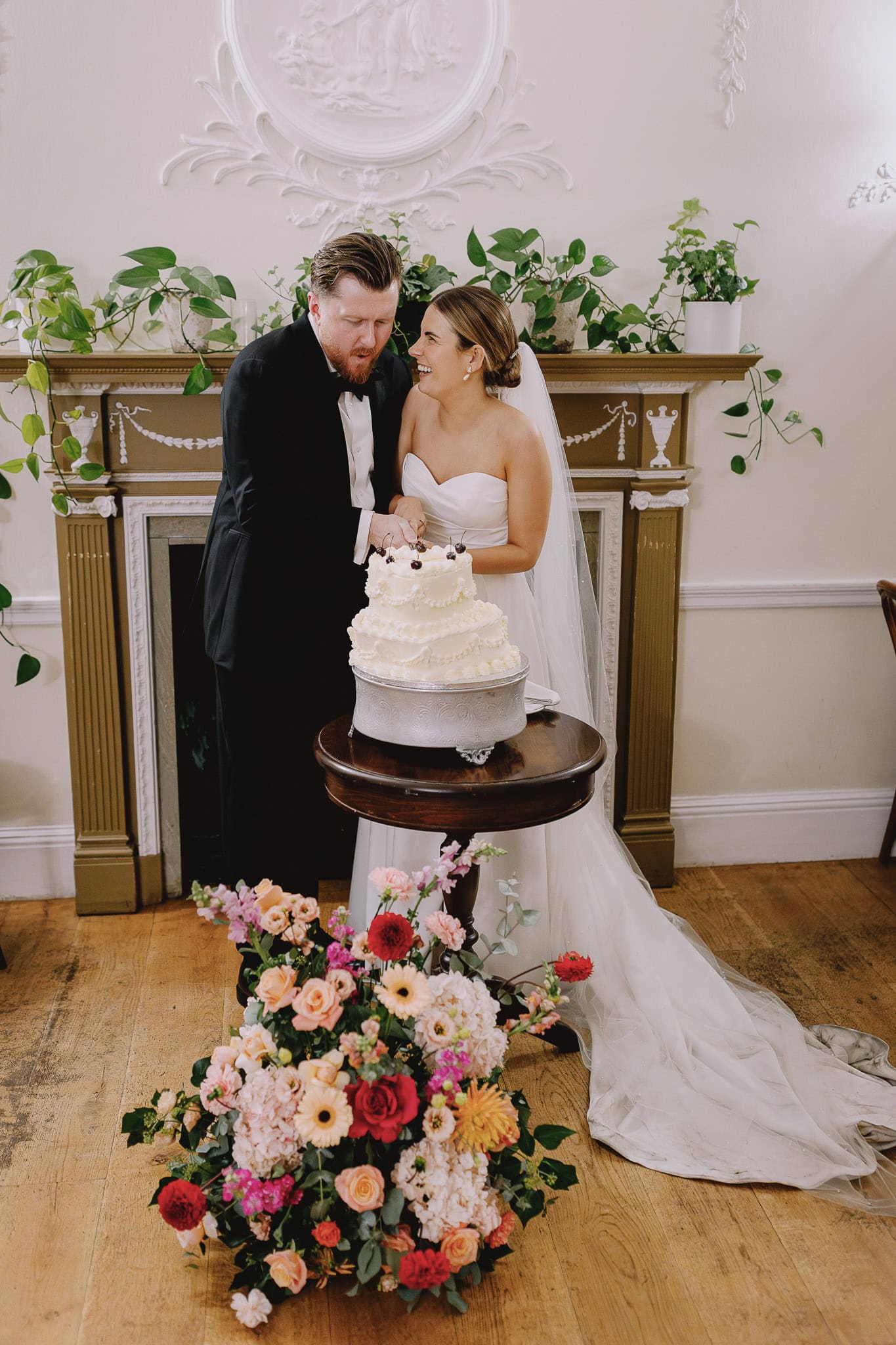 Bride and groom cutting their wedding cake, a charming moment from a Wedding Photography Portfolio.