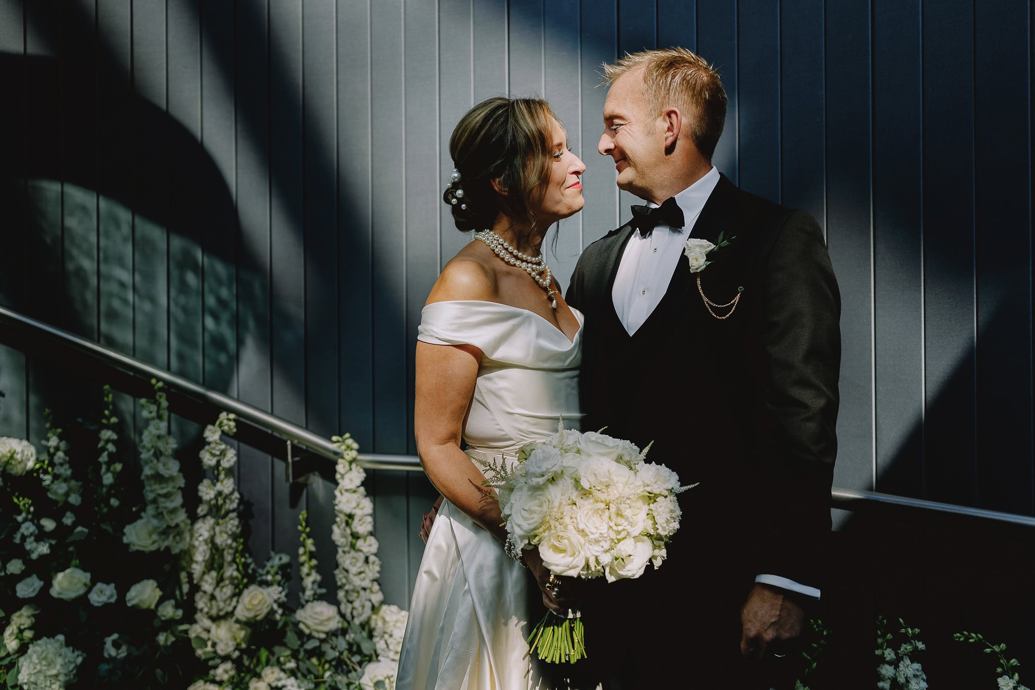 Bride and groom share a loving glance in editorial wedding photography.