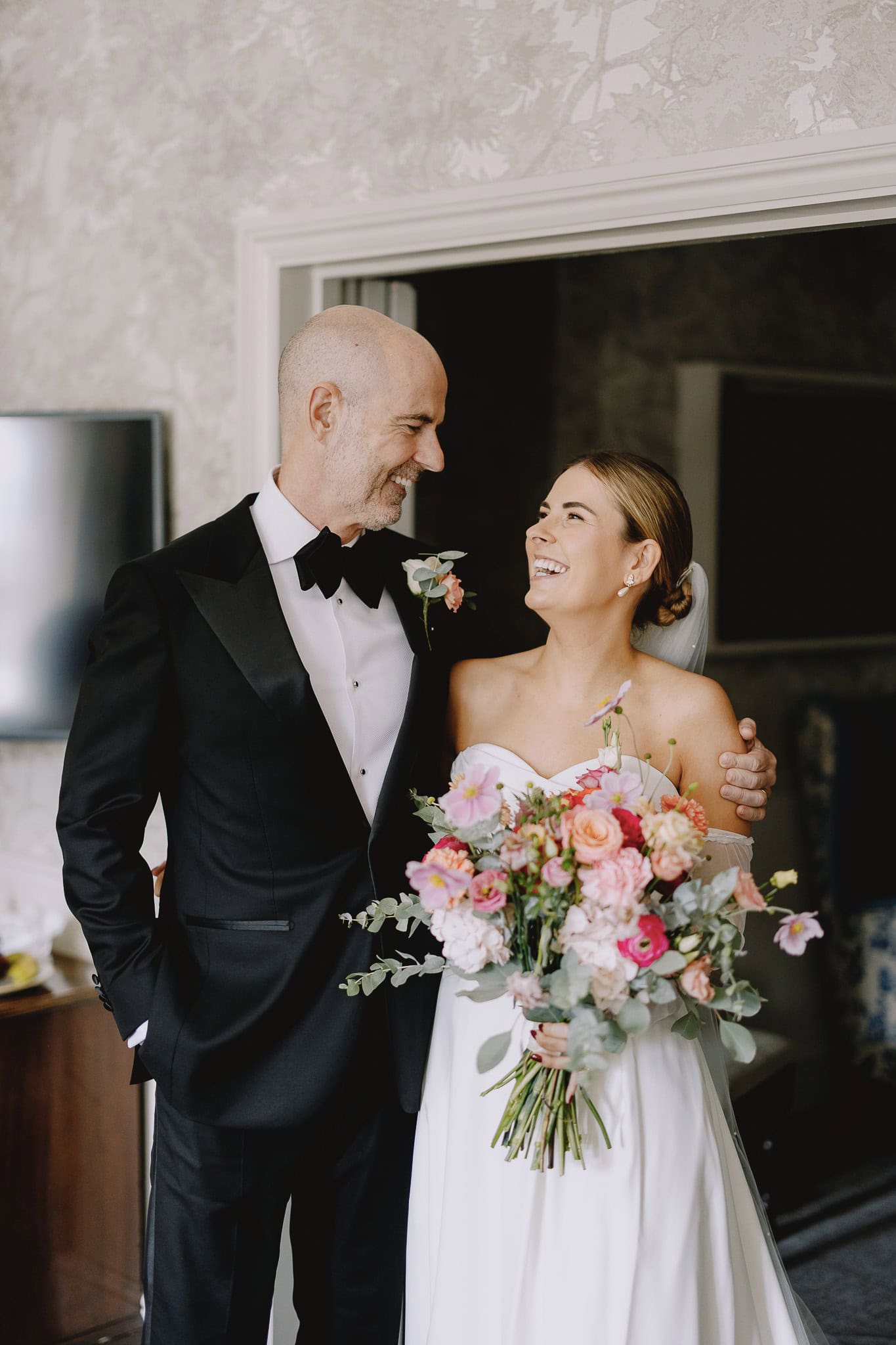 Happy bride and groom smiling at each other on their wedding day.