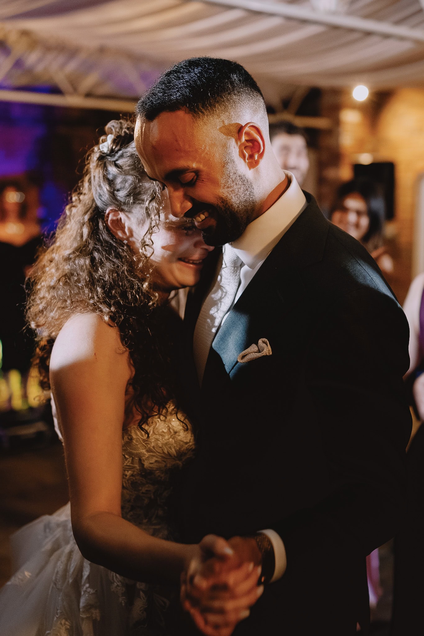 Bride and groom share a tender moment during their first dance at wedding reception.