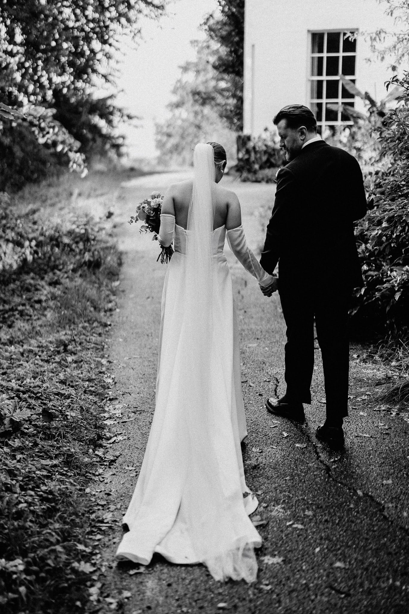 Bride and groom walking hand-in-hand on their wedding day.