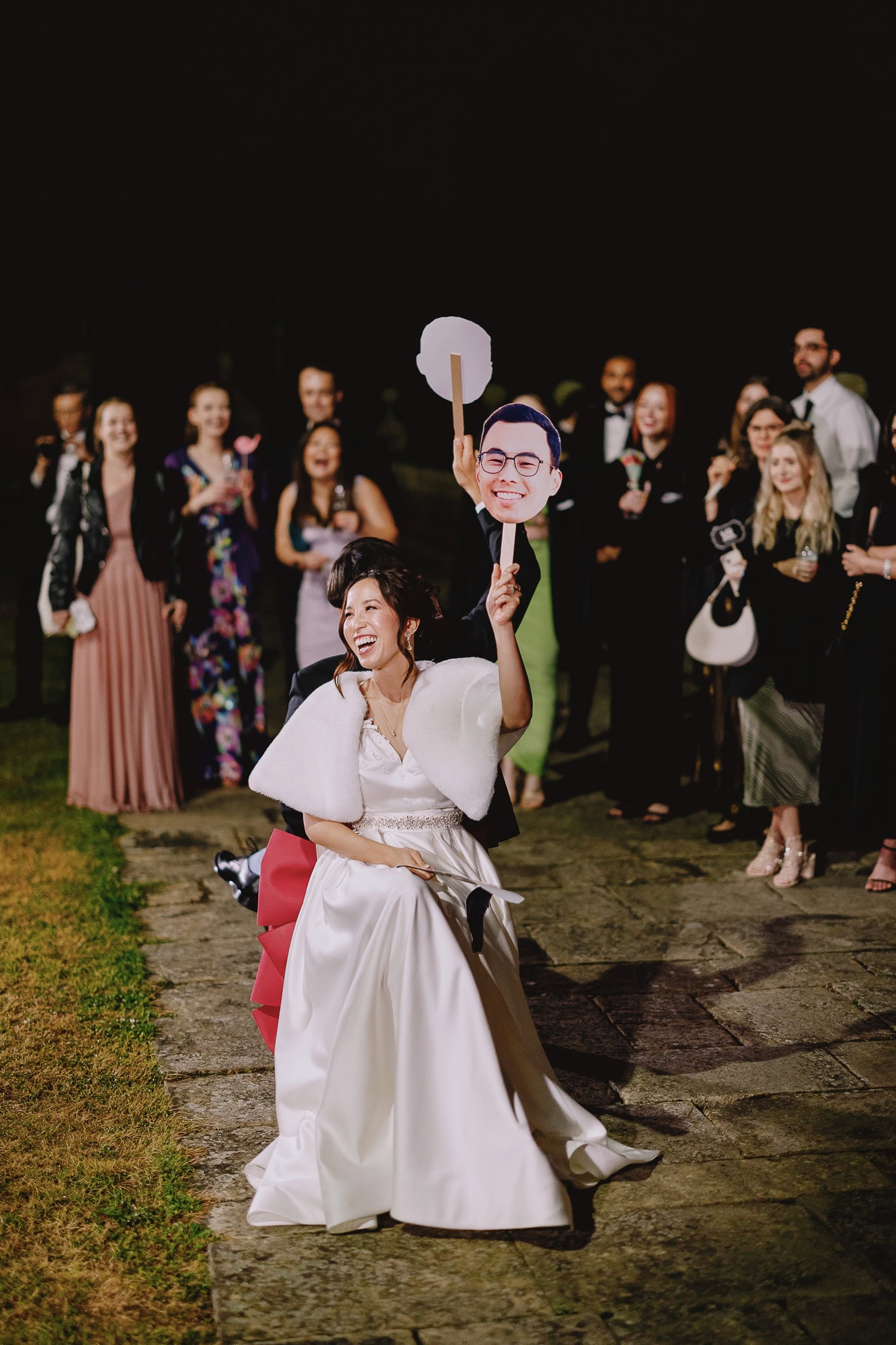 Bride celebrating with a groom face cutout at a sustainable wedding.