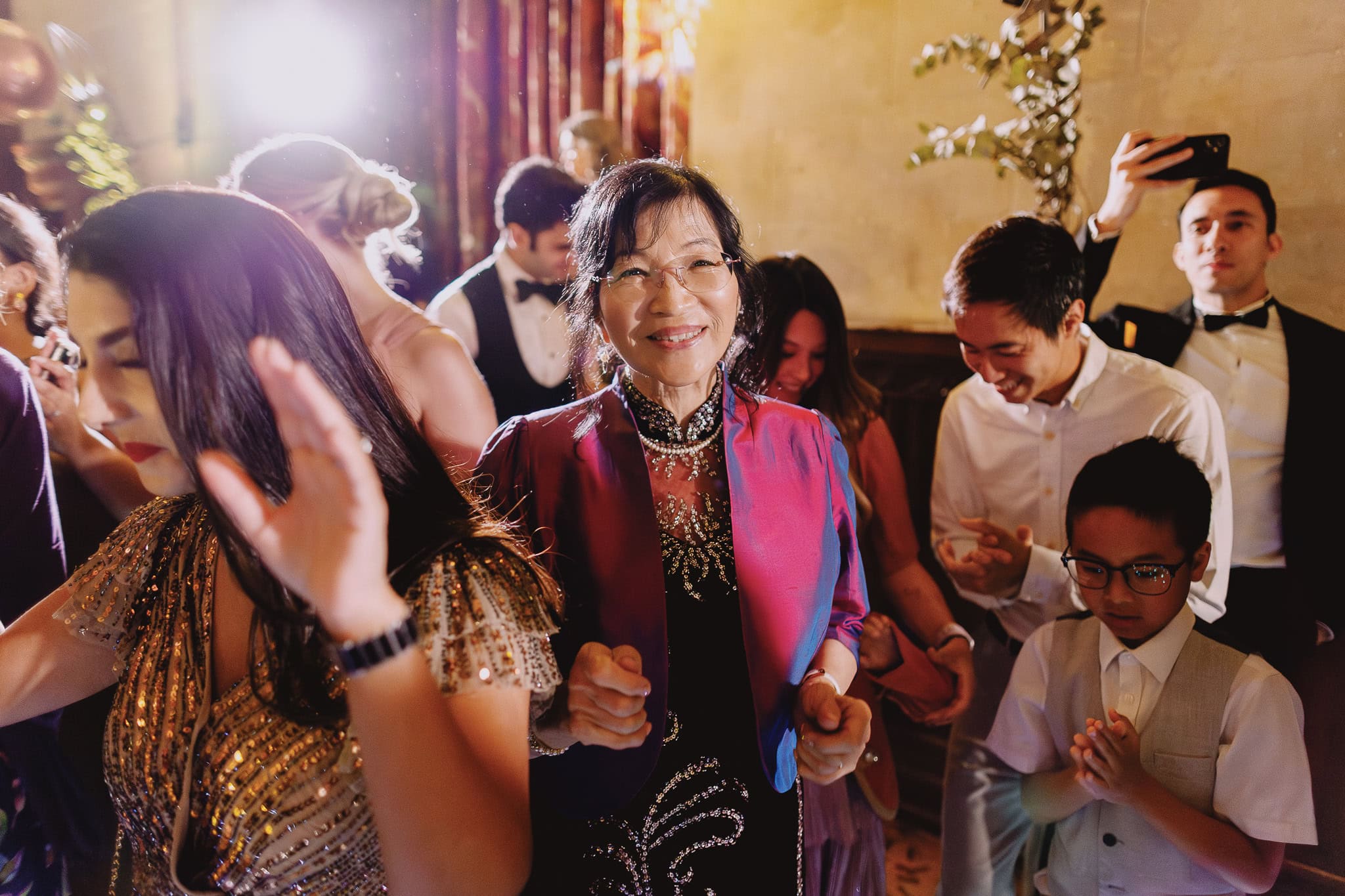 Woman joyfully dancing at a wedding reception.