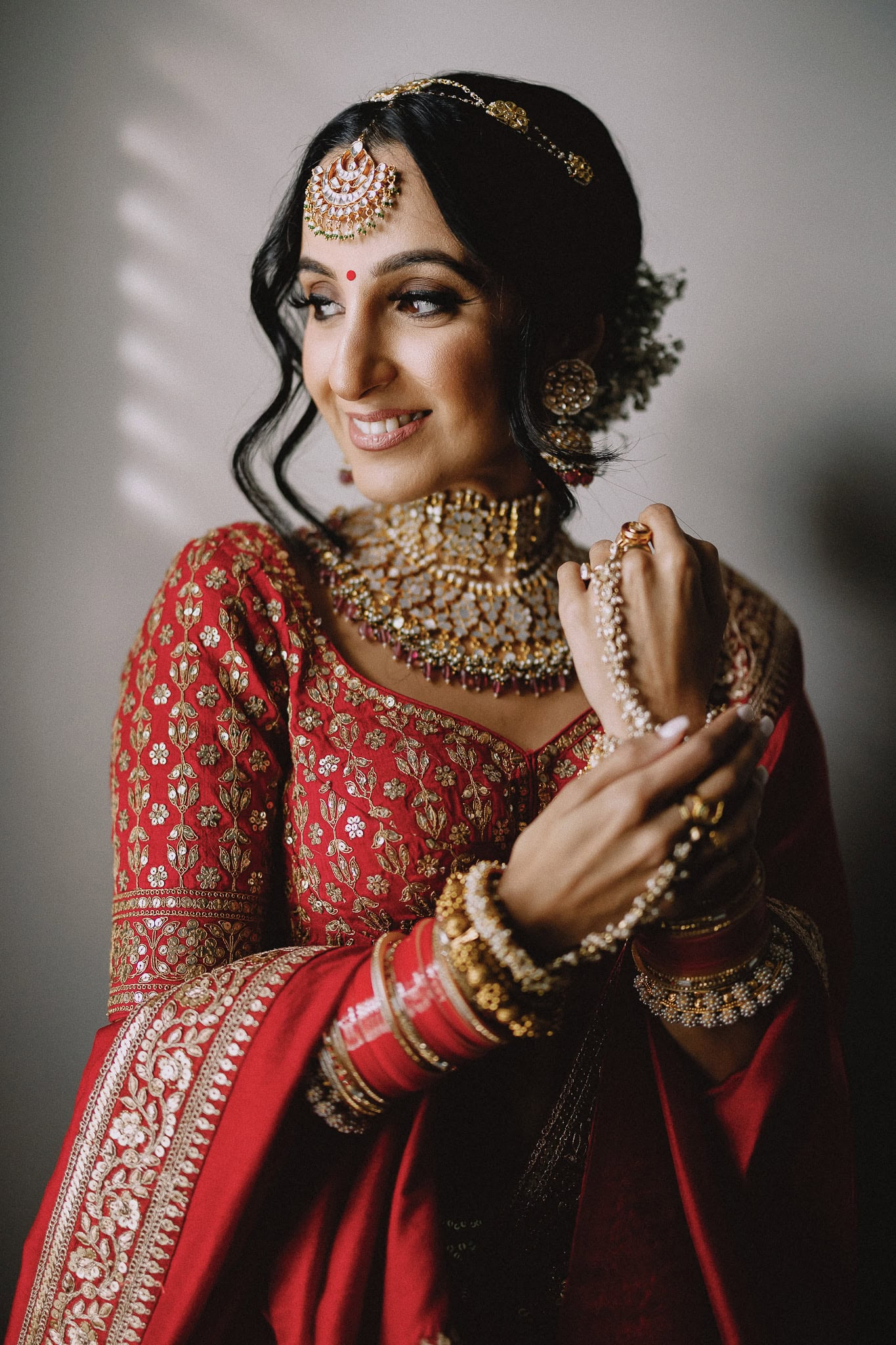 Indian bride in traditional red dress and gold jewelry