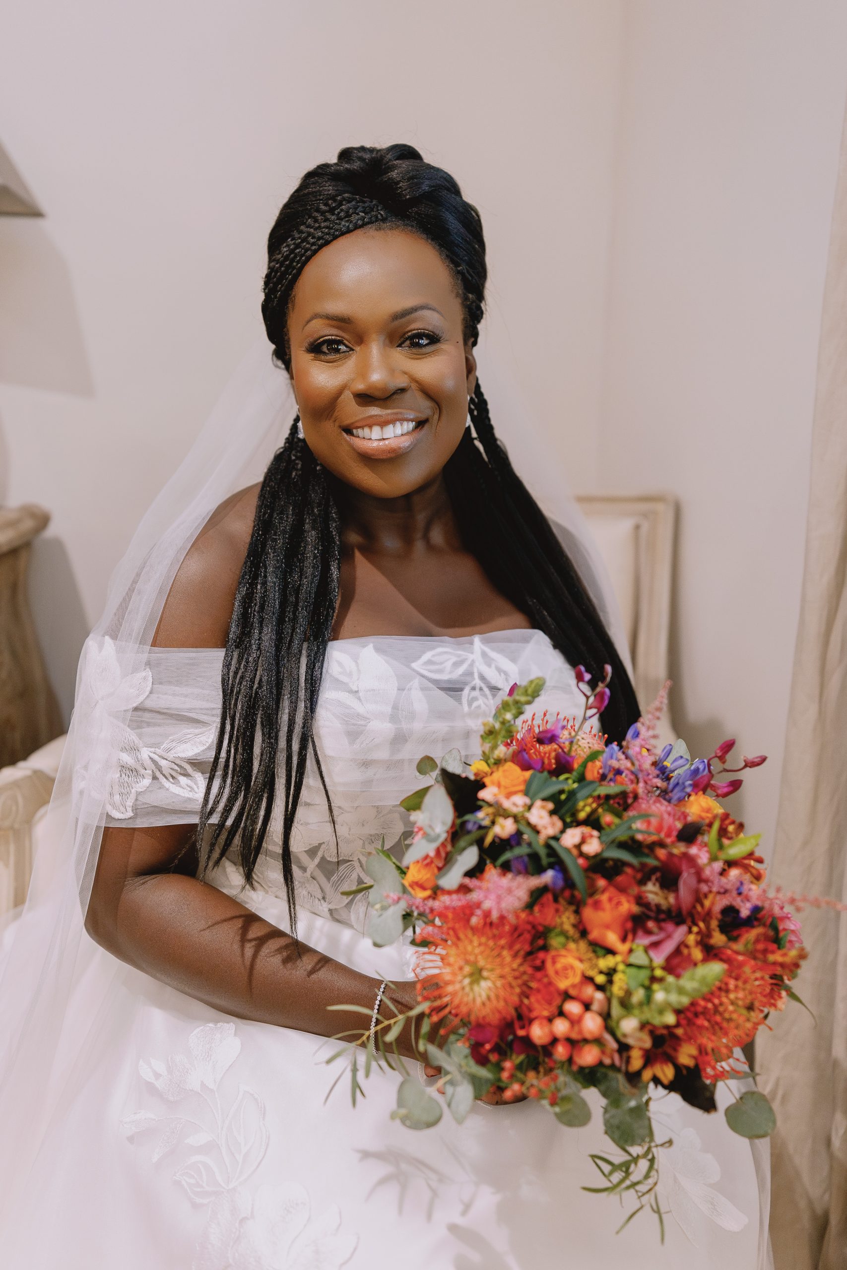 Bride with braided hair and wedding gown holding colorful bouquet at High Billinghurst Farm Wedding