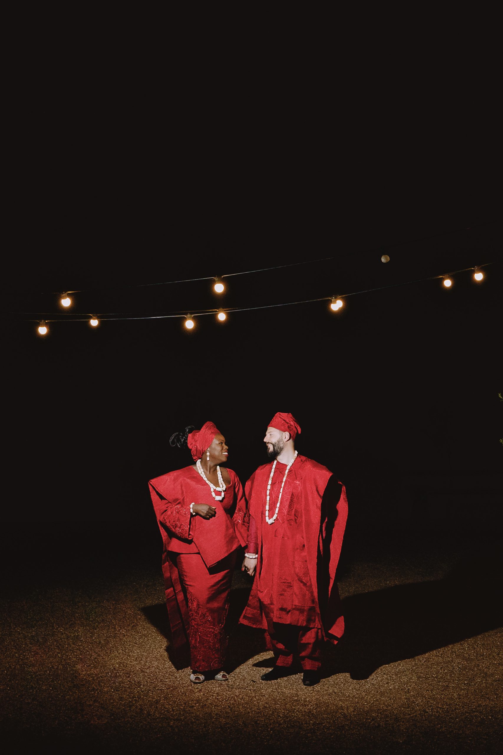 Tolu and Jack in red Asoebi at High Billinghurst Farm at night